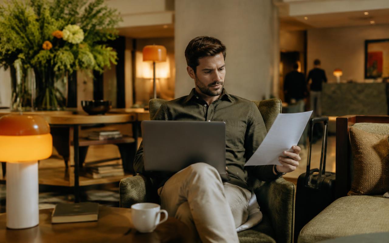 Business traveler reviewing a document in a hotel lobby